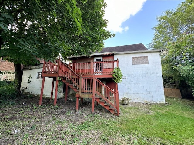 back of house featuring a lawn and a wooden deck