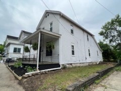 view of side of home featuring covered porch