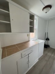 kitchen with hardwood / wood-style floors and white cabinetry