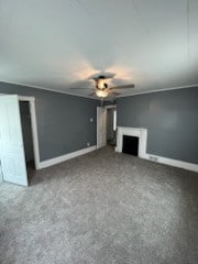 unfurnished living room featuring ceiling fan and dark colored carpet