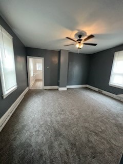 unfurnished room featuring dark carpet, plenty of natural light, and ceiling fan