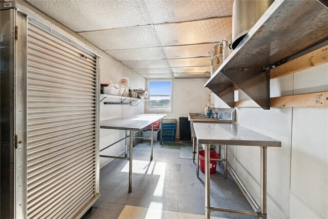 basement featuring tile flooring and a paneled ceiling