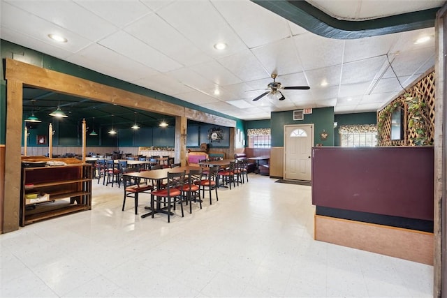 dining area with a drop ceiling and ceiling fan