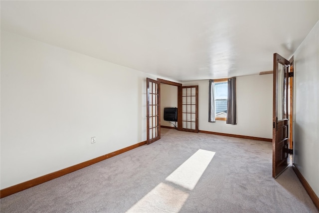 carpeted empty room featuring french doors