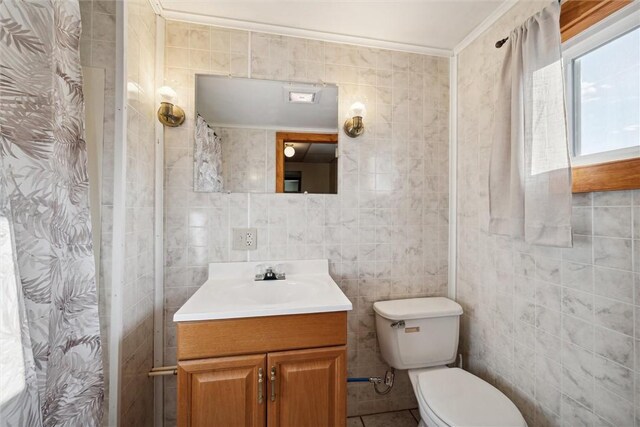 bathroom featuring crown molding, oversized vanity, toilet, and tile walls