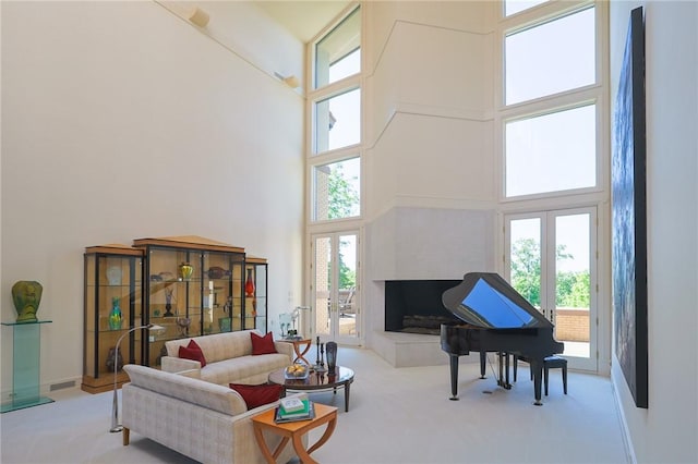 carpeted living room featuring french doors and a towering ceiling