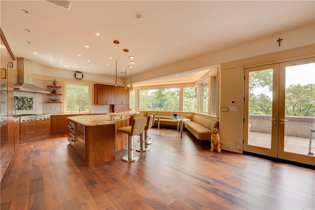 kitchen featuring ventilation hood, a center island, dark hardwood / wood-style floors, and decorative light fixtures