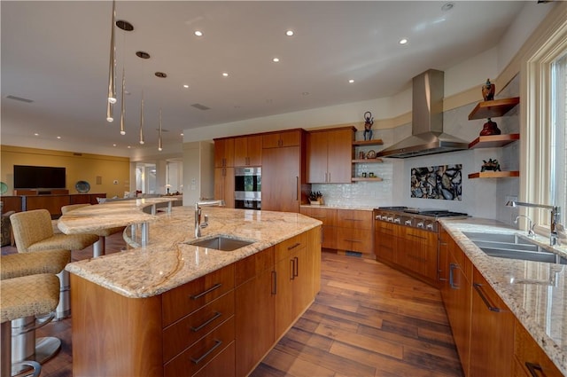 kitchen with extractor fan, sink, a spacious island, and stainless steel gas cooktop