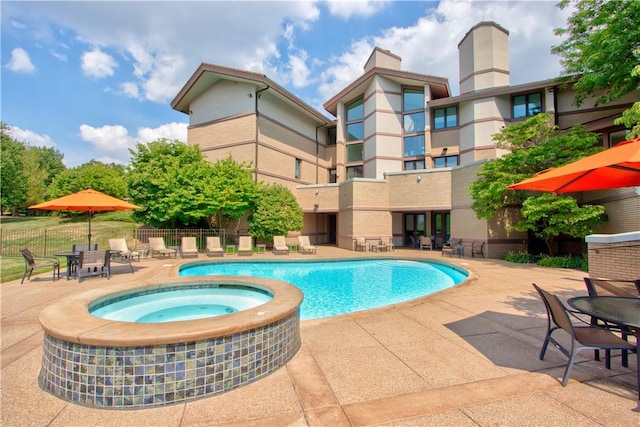 view of pool with an in ground hot tub and a patio area