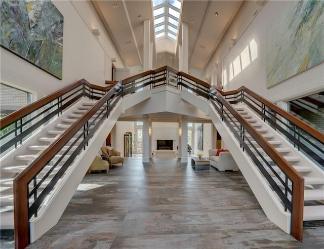 foyer entrance featuring a towering ceiling and a large fireplace