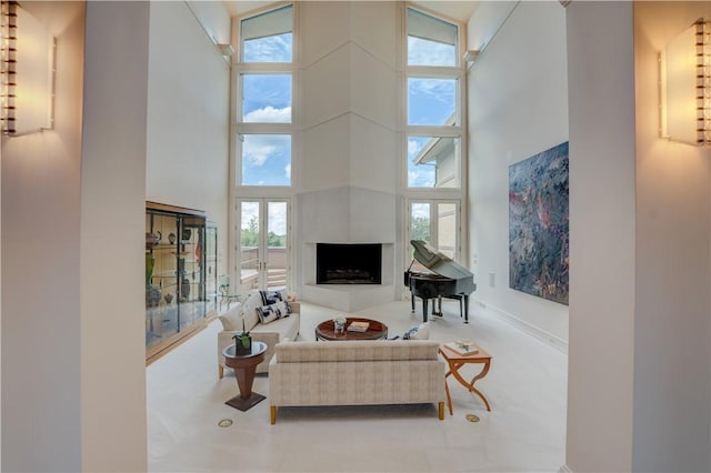 living room featuring a large fireplace and a high ceiling