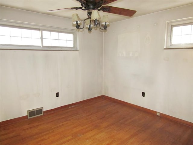 unfurnished room featuring hardwood / wood-style floors and ceiling fan with notable chandelier