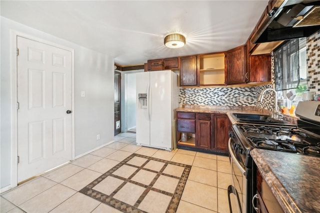 kitchen with gas range, extractor fan, sink, light tile patterned floors, and white fridge with ice dispenser