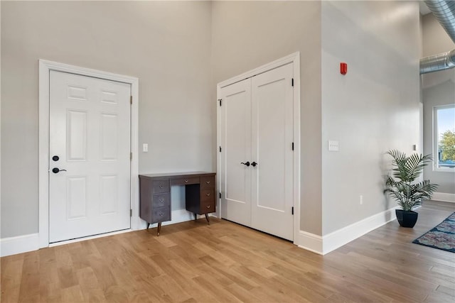 entryway featuring a high ceiling and light hardwood / wood-style floors