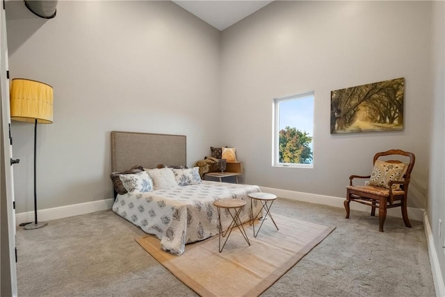 bedroom with light colored carpet and a high ceiling