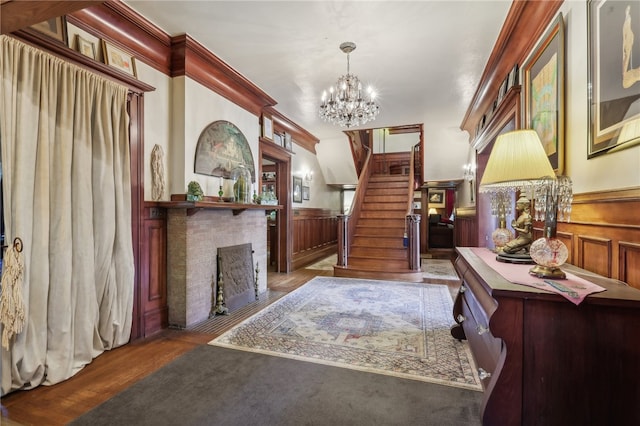 foyer featuring a notable chandelier, ornamental molding, and hardwood / wood-style floors