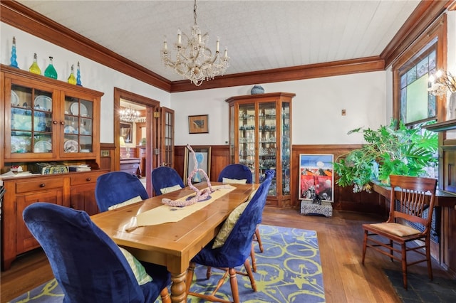 dining area featuring an inviting chandelier, wood-type flooring, and ornamental molding