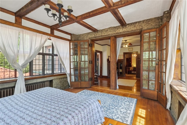 bedroom featuring beamed ceiling, hardwood / wood-style floors, coffered ceiling, and french doors