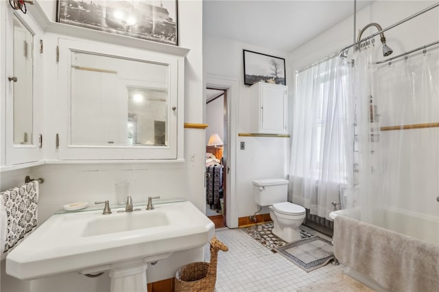 bathroom with tile floors, shower / bath combo, and toilet