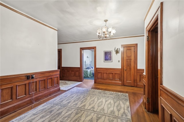 foyer with ornamental molding, a chandelier, and wood-type flooring