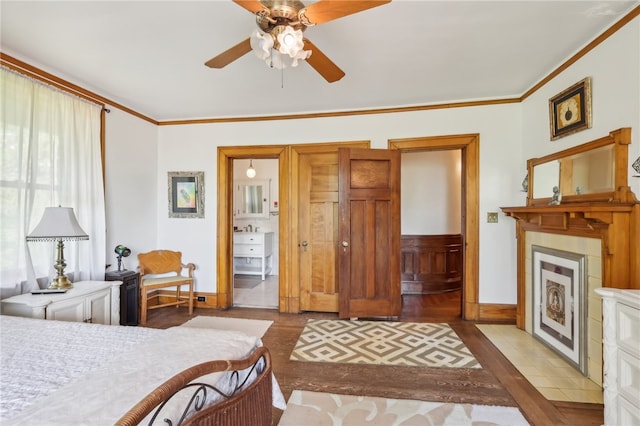 bedroom featuring tile floors, ceiling fan, a fireplace, and crown molding