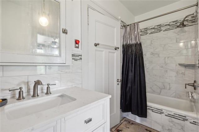 bathroom with tile walls, shower / bathtub combination with curtain, and oversized vanity