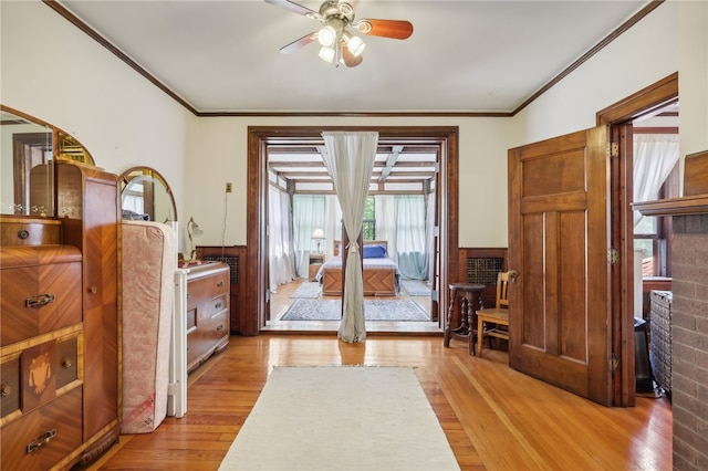 living area with ornamental molding, ceiling fan, and light wood-type flooring