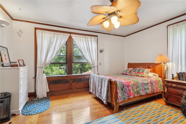 bedroom with crown molding, ceiling fan, and hardwood / wood-style floors