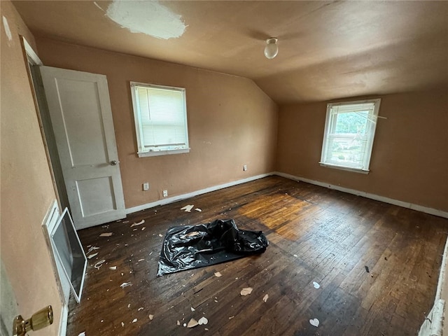 spare room with dark wood-type flooring and vaulted ceiling