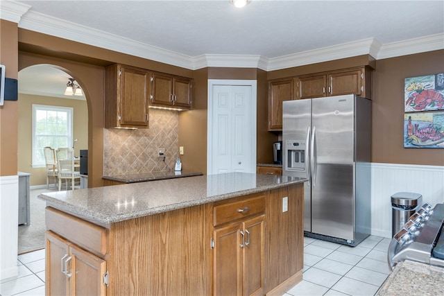 kitchen with a kitchen island, backsplash, stainless steel refrigerator with ice dispenser, and light tile floors