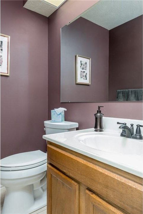 bathroom with vanity, toilet, and a textured ceiling