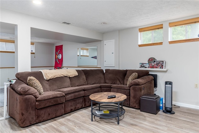 living room with a textured ceiling and light wood-type flooring