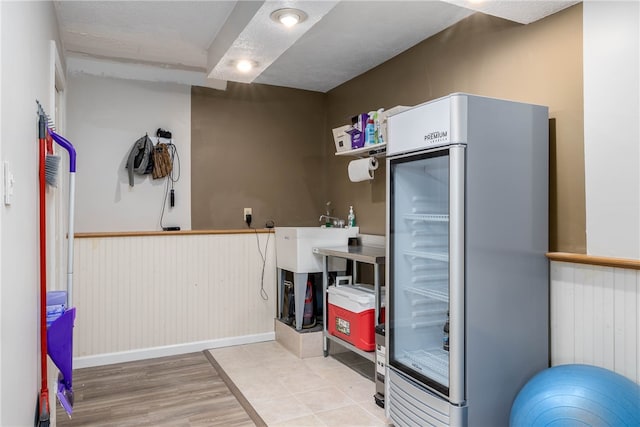 kitchen featuring sink, stainless steel refrigerator, and light hardwood / wood-style flooring