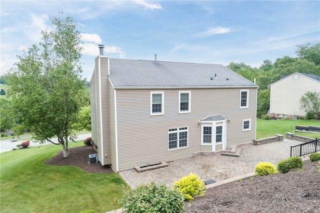 rear view of house with a lawn and central AC unit