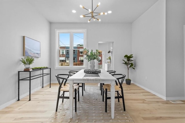 dining room featuring light hardwood / wood-style floors and a chandelier