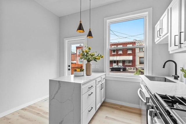 kitchen with a wealth of natural light, white cabinets, and light stone counters