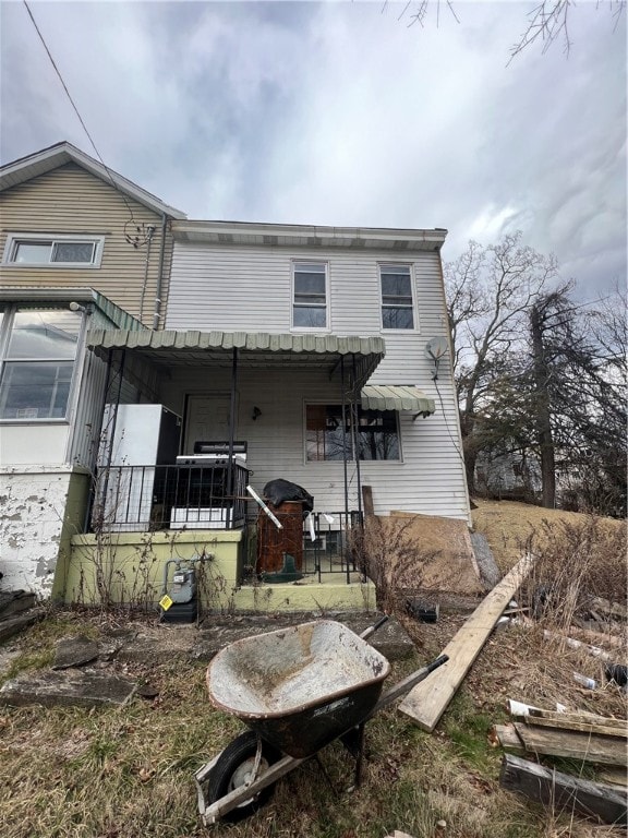 rear view of property featuring covered porch