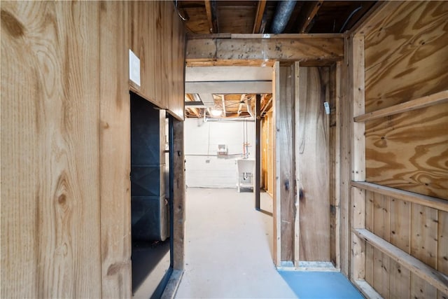 corridor featuring concrete flooring, sink, and wood walls