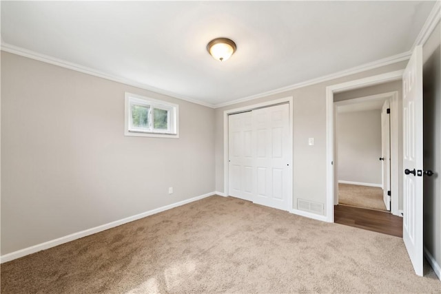 unfurnished bedroom featuring a closet, carpet, and ornamental molding