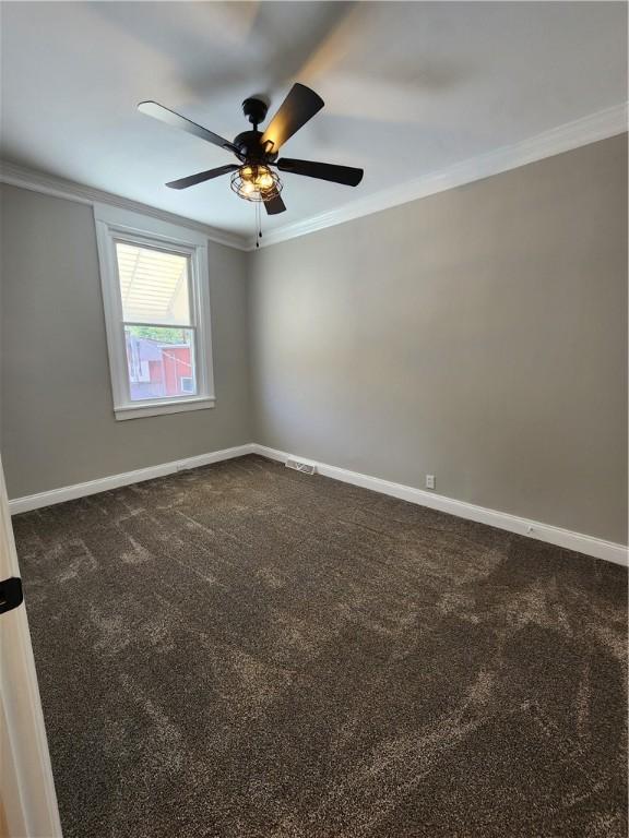 carpeted empty room with crown molding and ceiling fan