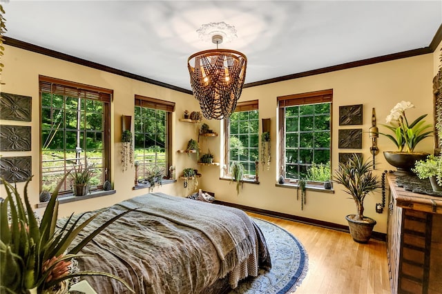 bedroom featuring hardwood / wood-style floors, a chandelier, crown molding, and multiple windows