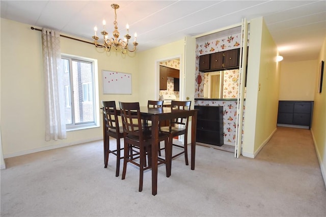 dining area featuring a chandelier and light colored carpet