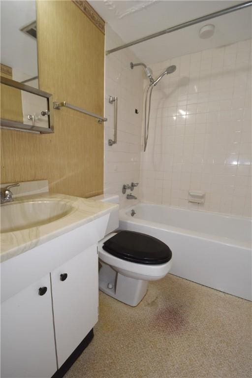 full bathroom featuring tiled shower / bath combo, vanity, and toilet