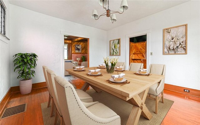 dining space with a notable chandelier and hardwood / wood-style floors