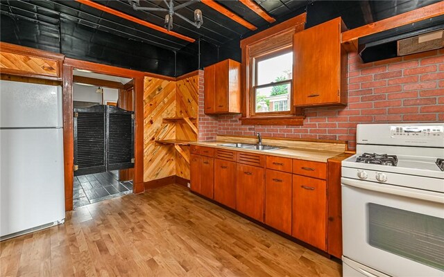 kitchen with sink, white appliances, and light hardwood / wood-style flooring