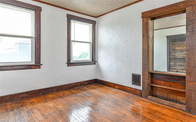 spare room with hardwood / wood-style floors and ornamental molding