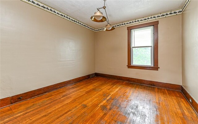 unfurnished room featuring a textured ceiling and wood-type flooring