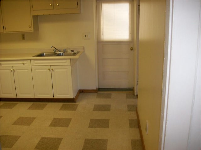 kitchen with sink, white cabinets, and light tile floors