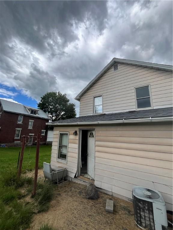 rear view of house featuring central air condition unit