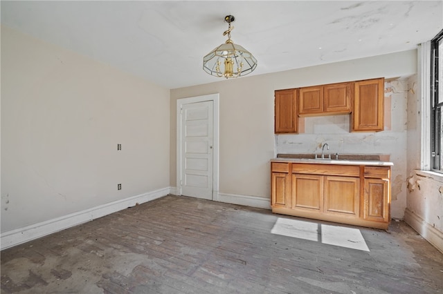 kitchen with a notable chandelier, sink, tasteful backsplash, and pendant lighting